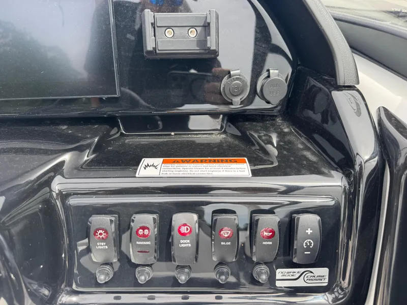 Slide: The Image of Control panel of 2025 Yamaha Boats 195S with various switches and warning label. - 16