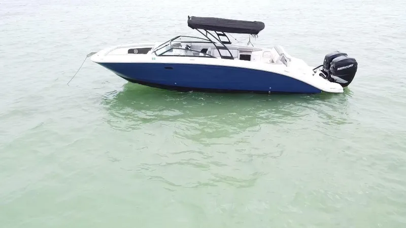 Slide: The Image of 2017 Sea Ray SDX 290 Outboard boat on calm water, featuring a sleek design and black canopy. - 11