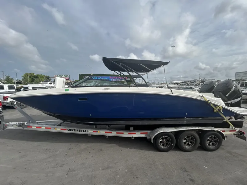 Slide: The Image of 2017 Sea Ray SDX 290 Outboard boat on trailer, blue hull, parked outdoors. - 25
