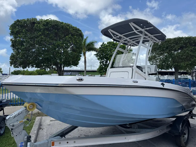Slide: The Image of 2025 Yamaha Boats 195 FSH Sport in a parking lot, showcasing sleek design and blue hull. - 1