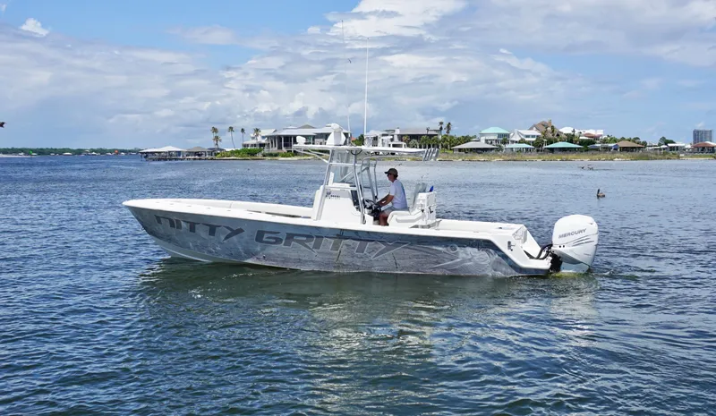 Slide: The Image of 2009 SeaVee 32OB boat on water, clear sky, coastal background. - 0