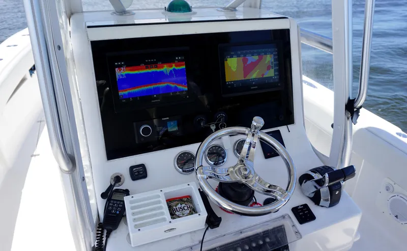 Slide: The Image of 2009 SeaVee 32OB boat console with navigation screens, steering wheel, and controls on open water. - 14