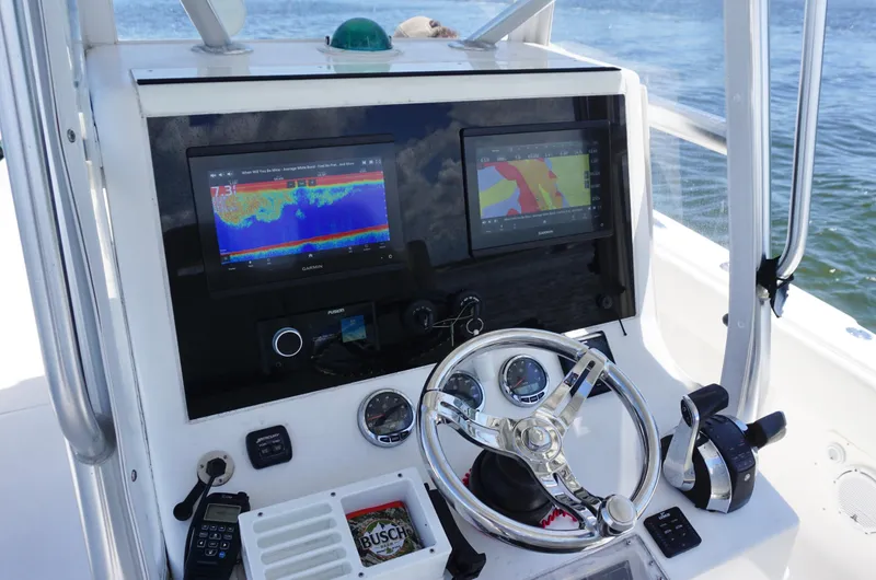 Slide: The Image of 2009 SeaVee 32OB boat dashboard with dual navigation screens and steering wheel. - 16