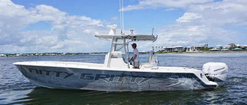 Slide: The Image of 2009 SeaVee 32OB boat on water, clear sky, person at helm, coastal background. - 2