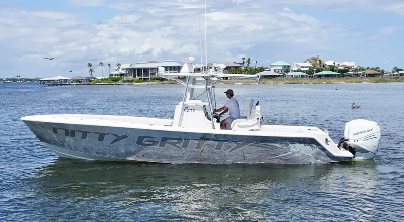 Slide: The Image of 2009 SeaVee 32OB boat on water, side view, with person at helm, coastal background. - 3