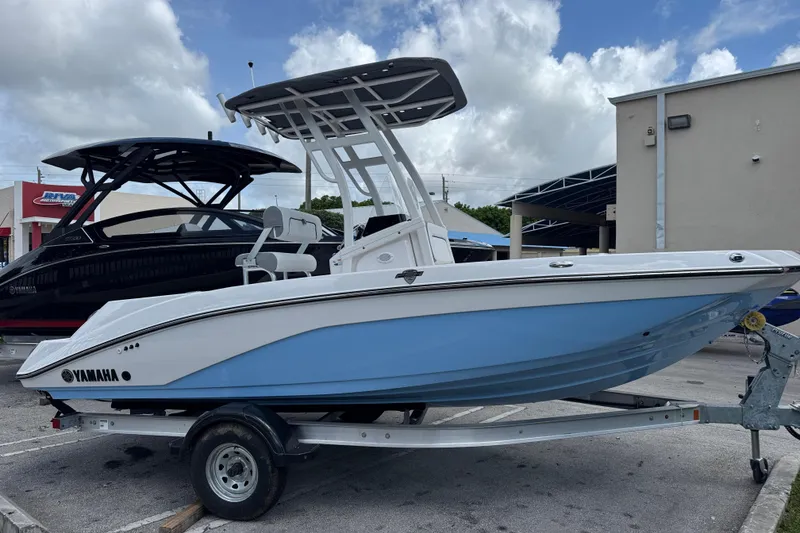 The Image of 2025 Yamaha Boats 195 FSH Sport in blue on trailer, parked outdoors. - 0