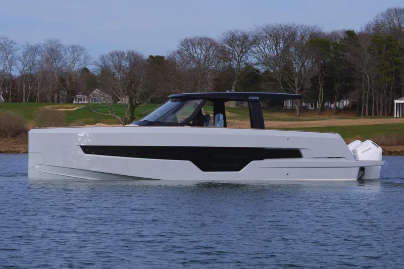 Slide: The Image of 2025 Fjord 41 XP luxury yacht on calm water, surrounded by trees and shoreline. - 11