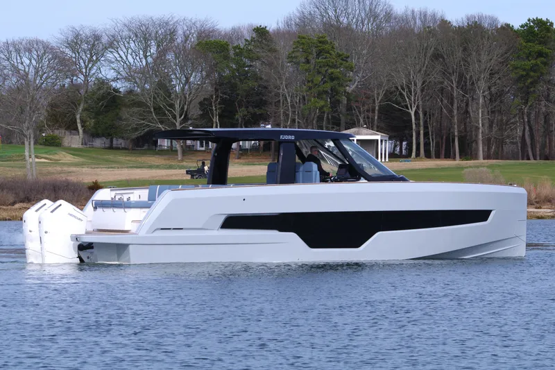 Slide: The Image of 2025 Fjord 41 XP yacht on calm water with wooded shoreline background. - 3