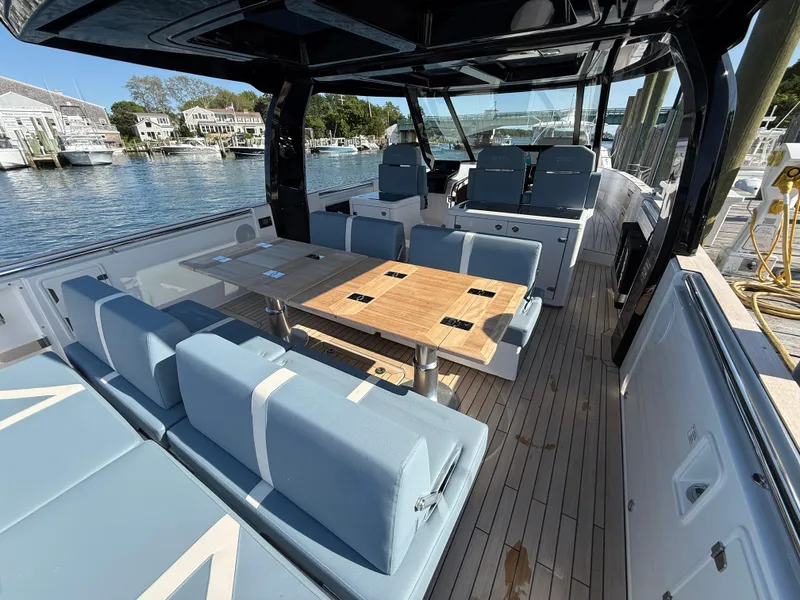 Slide: The Image of 2025 Fjord 41 XP yacht interior with modern seating and wooden table, docked by the water. - 34