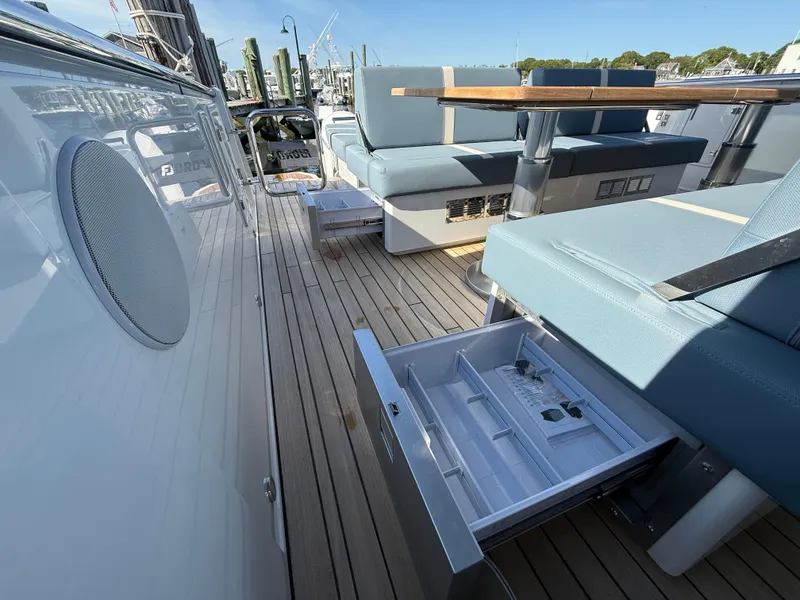 Slide: The Image of 2025 Fjord 41 XP yacht deck with seating, table, and open storage drawer. - 37