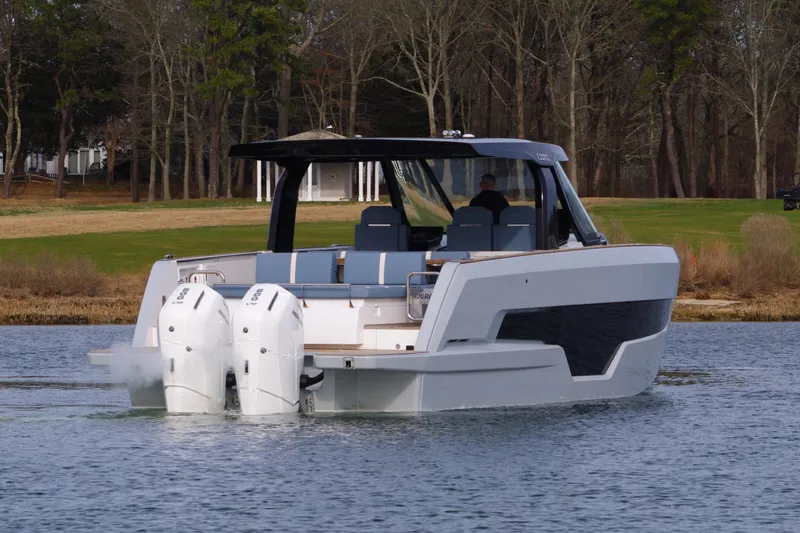 Slide: The Image of 2025 Fjord 41 XP boat with dual outboard engines on a calm lake. - 5