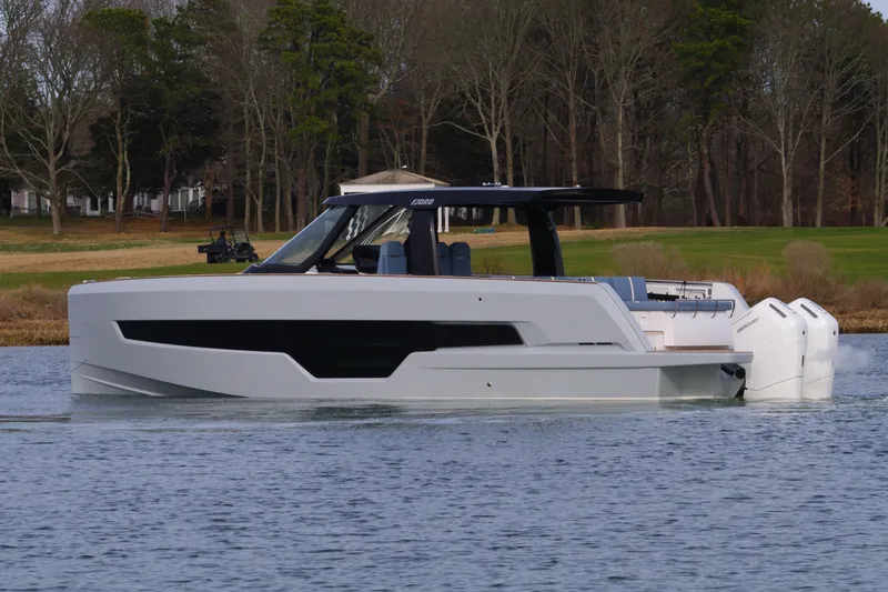 Slide: The Image of 2025 Fjord 41 XP luxury yacht cruising on a serene lake with wooded shoreline. - 9