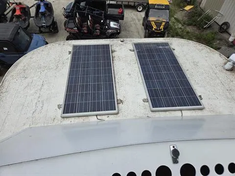 Slide: The Image of Solar panels on 1984 King's Craft Coastal Cruiser roof, surrounded by various vehicles. - 12