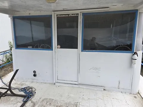 Slide: The Image of 1984 King's Craft Coastal Cruiser boat exterior with windows and door. - 14