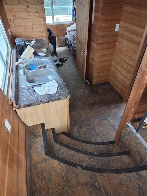 Slide: The Image of Interior of a 1984 King's Craft Coastal Cruiser with wooden walls and a compact kitchen area. - 18