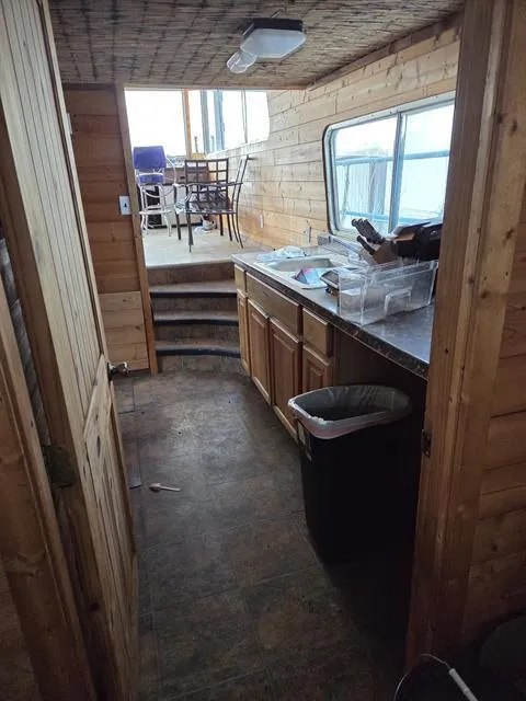 Slide: The Image of Interior of 1984 King's Craft Coastal Cruiser with wooden cabinetry and steps leading to seating area. - 20