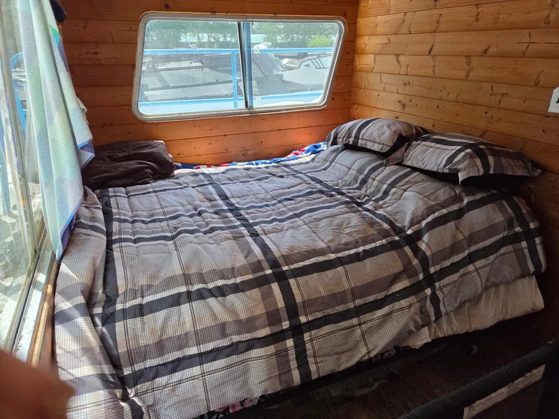 Slide: The Image of Cozy bedroom with plaid bedding inside 1984 King's Craft Coastal Cruiser boat. - 21