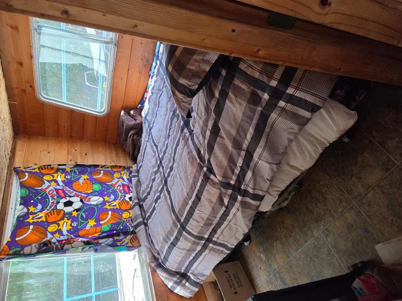 Slide: The Image of Cozy bedroom in 1984 King's Craft Coastal Cruiser with colorful curtains and plaid bedding. - 22