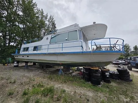 Slide: The Image of 1984 King's Craft Coastal Cruiser boat on land, surrounded by trees and tires. - 3