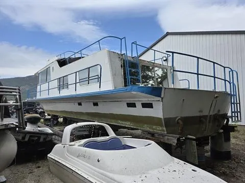 Slide: The Image of 1984 King's Craft Coastal Cruiser boat on land, near a white building, under a cloudy sky. - 6