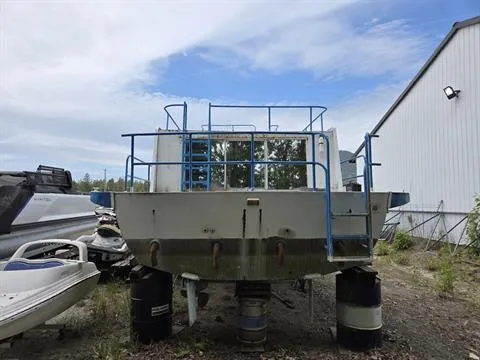 Slide: The Image of 1984 King's Craft Coastal Cruiser boat on barrels, outdoor storage, blue railings, overcast sky. - 8