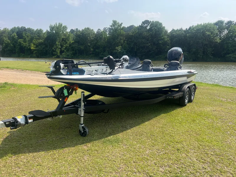 The Image of 2025 Skeeter ZXR 21 boat on trailer by a lake, surrounded by trees. - 0