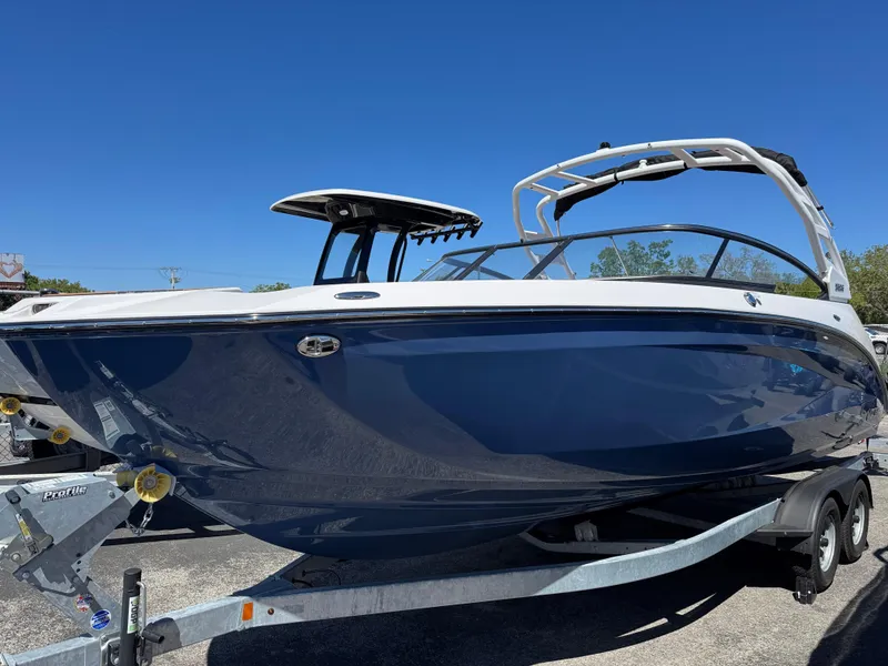 The Image of 2025 Yamaha Boats 252S on trailer, sleek blue design under clear sky. - 0