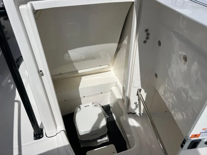 Slide: The Image of 2025 Robalo R200 Center Console boat interior with compact marine toilet. - 17