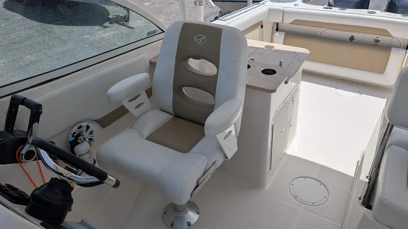 Slide: The Image of Captain's chair on 2016 Sailfish 275 DC boat, featuring steering wheel and control panel. - 11