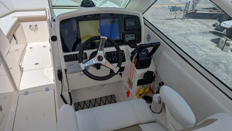 Slide: The Image of Helm of 2016 Sailfish 275 DC boat with steering wheel and navigation controls. - 12