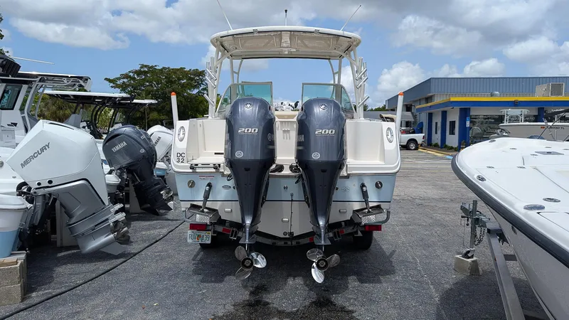 Slide: The Image of 2016 Sailfish 275 DC boat with twin 200 horsepower engines, parked in a marina. - 3