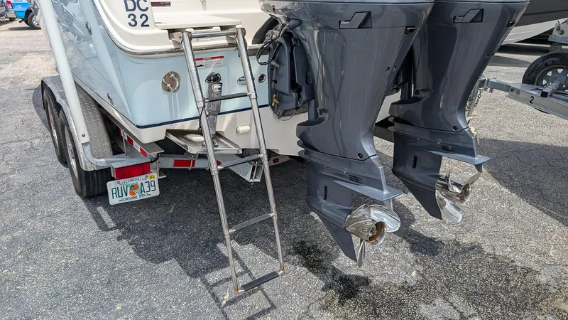 Slide: The Image of 2016 Sailfish 275 DC boat with dual outboard motors and a ladder on a trailer. - 4