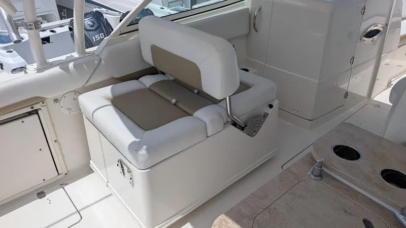 Slide: The Image of 2016 Sailfish 275 DC boat interior with cushioned seating and cup holders. - 8