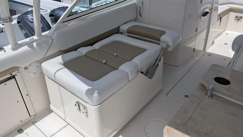 Slide: The Image of 2016 Sailfish 275 DC boat interior with cushioned seating and storage. - 9