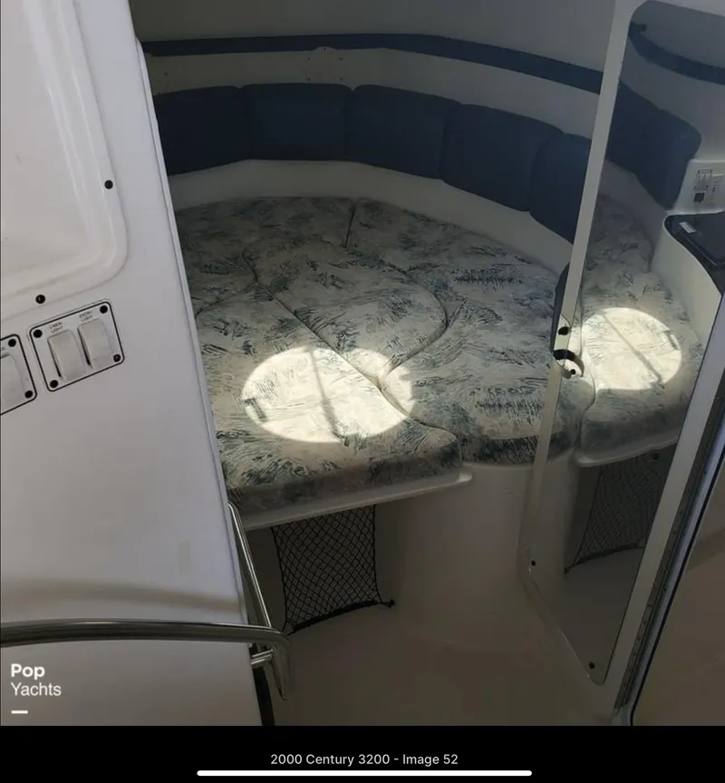 Slide: The Image of 2000 Century 3200 WA cabin interior with cushioned seating and storage. - 14