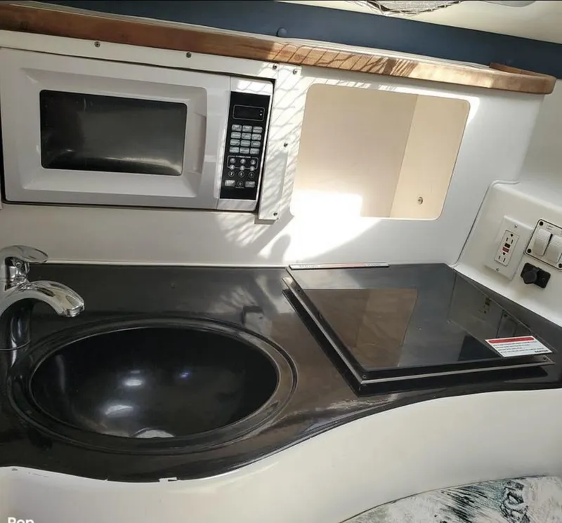 Slide: The Image of Compact kitchen area in a 2000 Century 3200 WA boat with sink, microwave, and stove. - 15