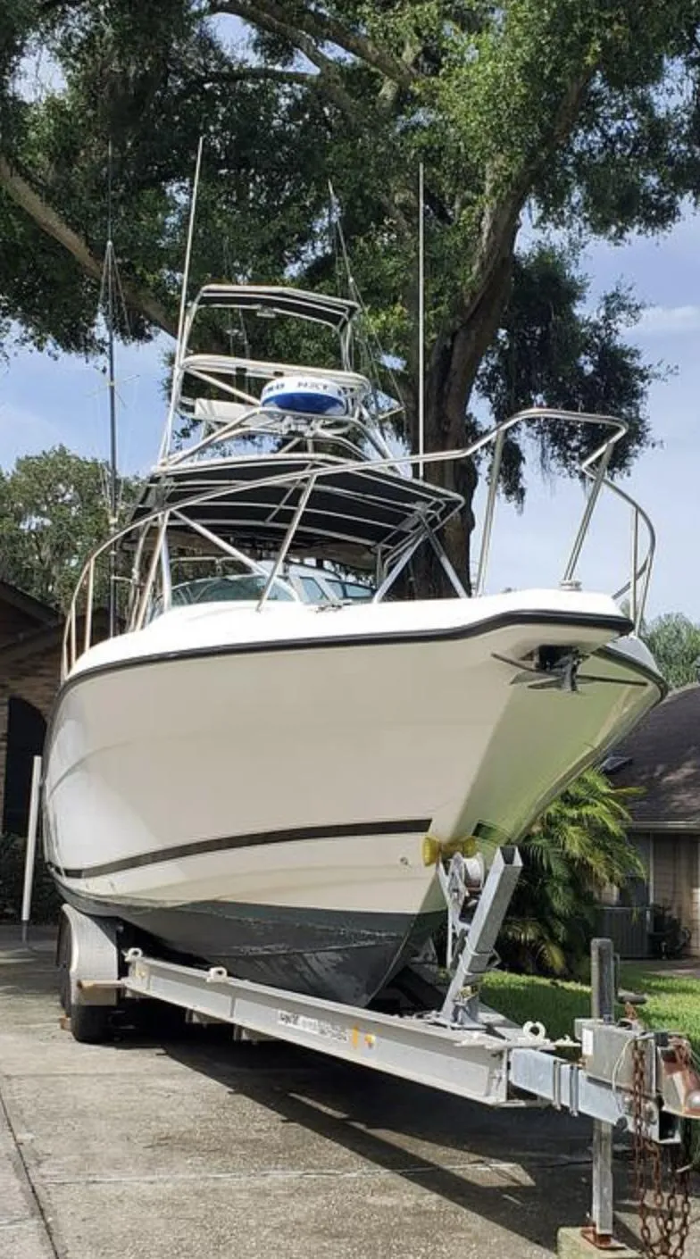 Slide: The Image of Century 3200 WA 2000 model boat on trailer, parked outdoors under trees. - 19