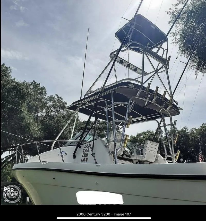 Slide: The Image of 2000 Century 3200 WA boat with tower, docked under a clear sky. - 20