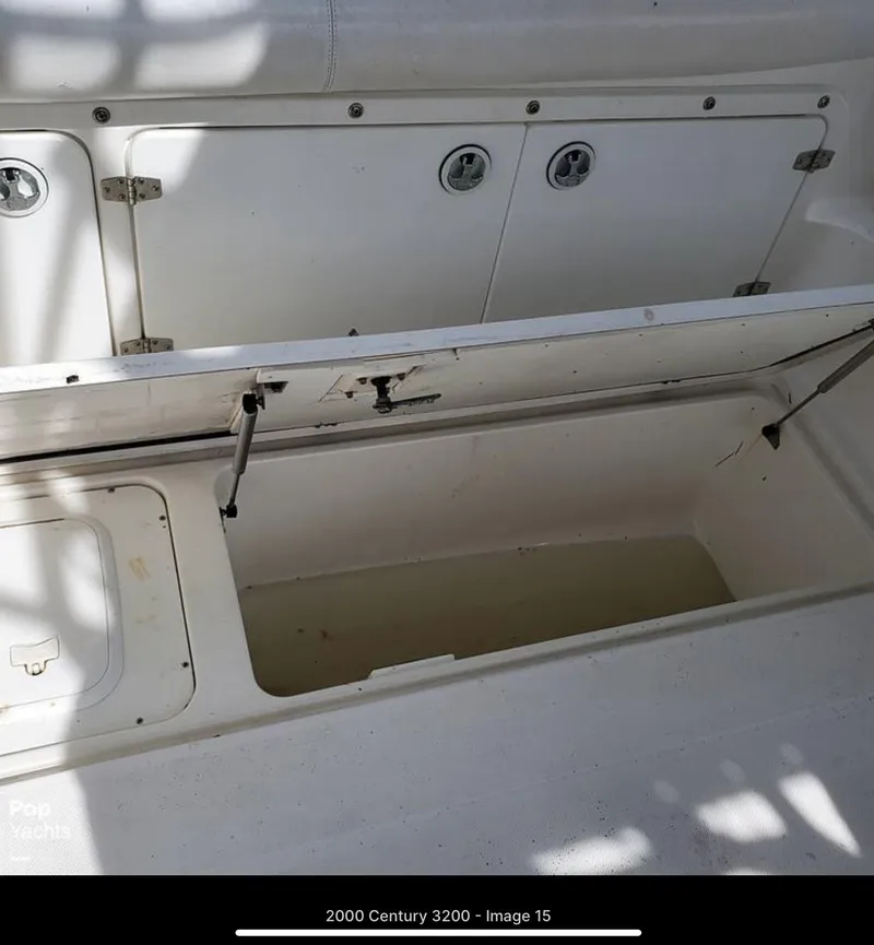 Slide: The Image of 2000 Century 3200 WA boat storage compartment with open hatch, showcasing interior space. - 8