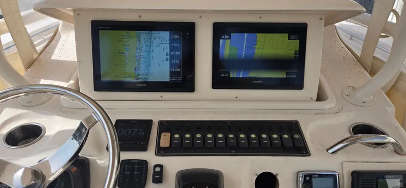 Slide: The Image of Helm of 2016 Grady-White Canyon 306 with dual navigation screens and controls. - 18