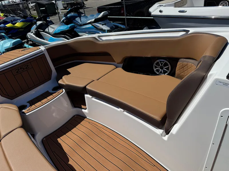 Slide: The Image of 2025 Yamaha Boats 252S interior with brown seating and wood-style flooring. - 23