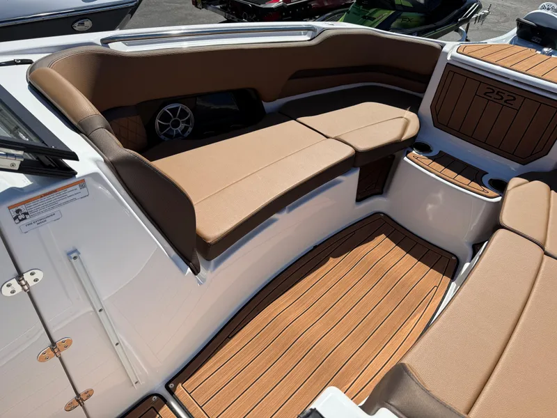 Slide: The Image of 2025 Yamaha Boats 252S interior with tan seating and wood-style flooring. - 24