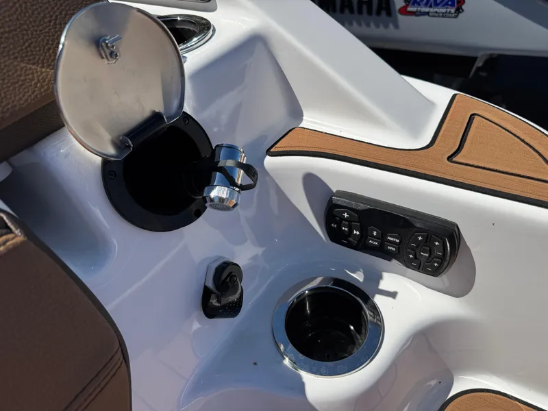 Slide: The Image of 2025 Yamaha Boats 252S dashboard with controls, cup holder, and fuel cap. - 3