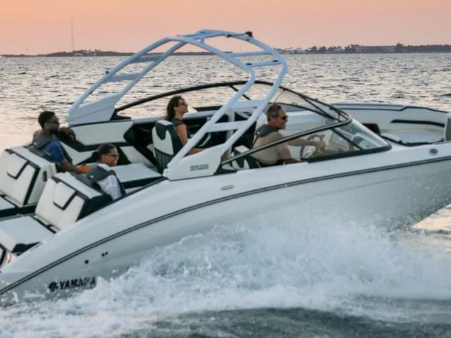 Slide: The Image of 2025 Yamaha Boats 252S cruising on water at sunset with passengers onboard. - 37