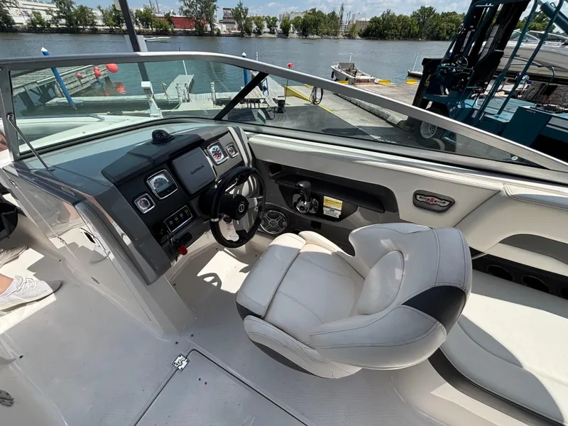Slide: The Image of 2013 Chaparral 246 SXI boat interior with steering wheel and dashboard by the water. - 12