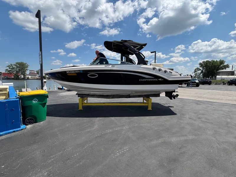 Slide: The Image of 2013 Chaparral 246 SXI boat on a lift by the waterfront under a cloudy sky. - 5