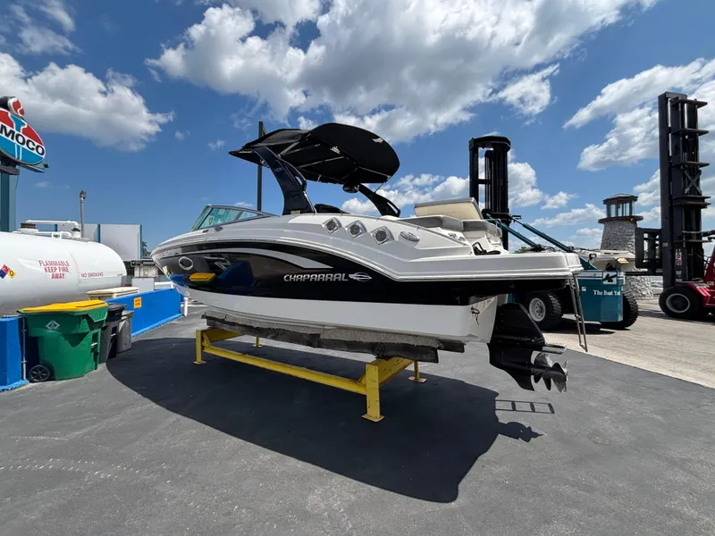 Slide: The Image of 2013 Chaparral 246 SXI boat on display under a clear blue sky. - 7