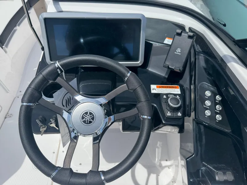 Slide: The Image of 2025 Yamaha Boats 252S dashboard with steering wheel and touchscreen display. - 17