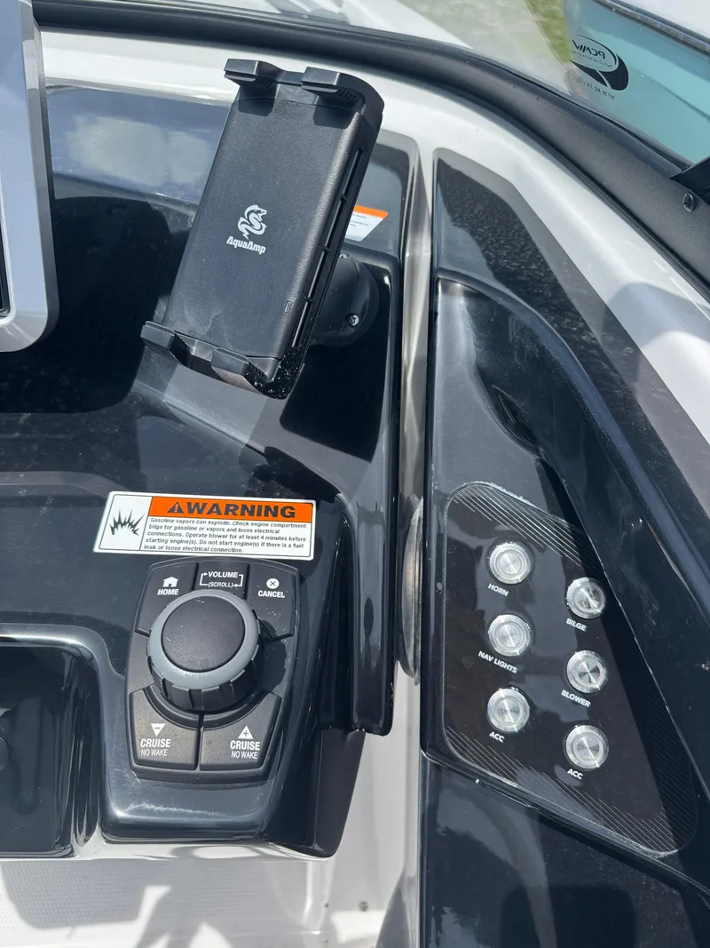 Slide: The Image of Control panel of 2025 Yamaha Boats 252S with phone holder and warning label. - 18