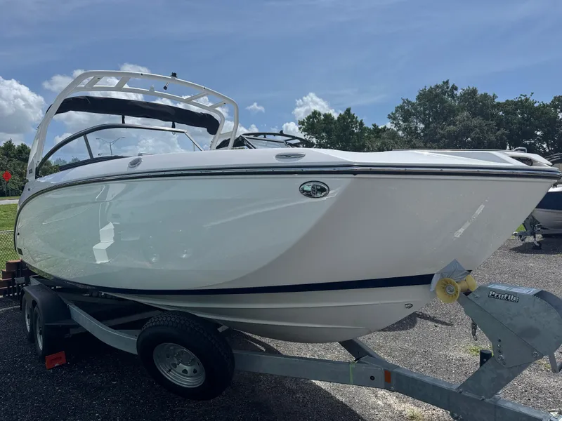 Slide: The Image of 2025 Yamaha Boats 252S on trailer, sleek white design under clear blue sky. - 2